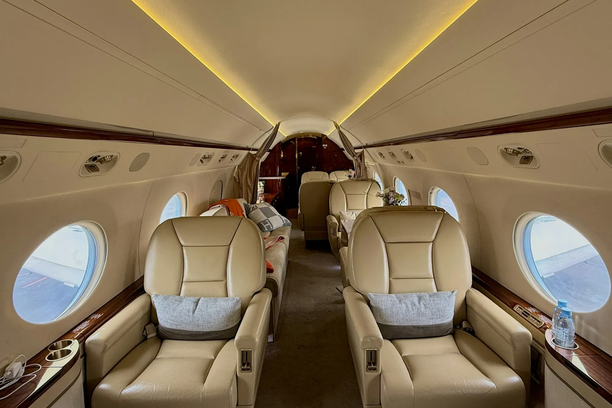 Warm-lit private cabin with cream leather seats and polished wood trim