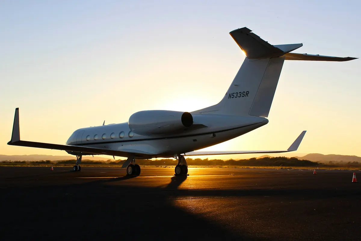 Large-cabin jet silhouetted on the ramp at sunset